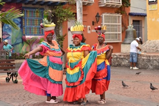 a group of women in colorful dresses standing next to each other