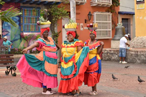 a group of women in colorful dresses standing next to each other