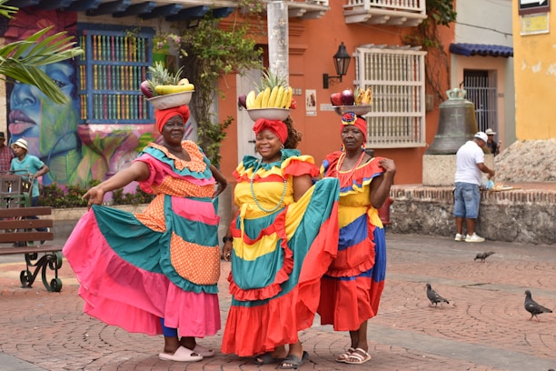 a group of women in colorful dresses standing next to each other