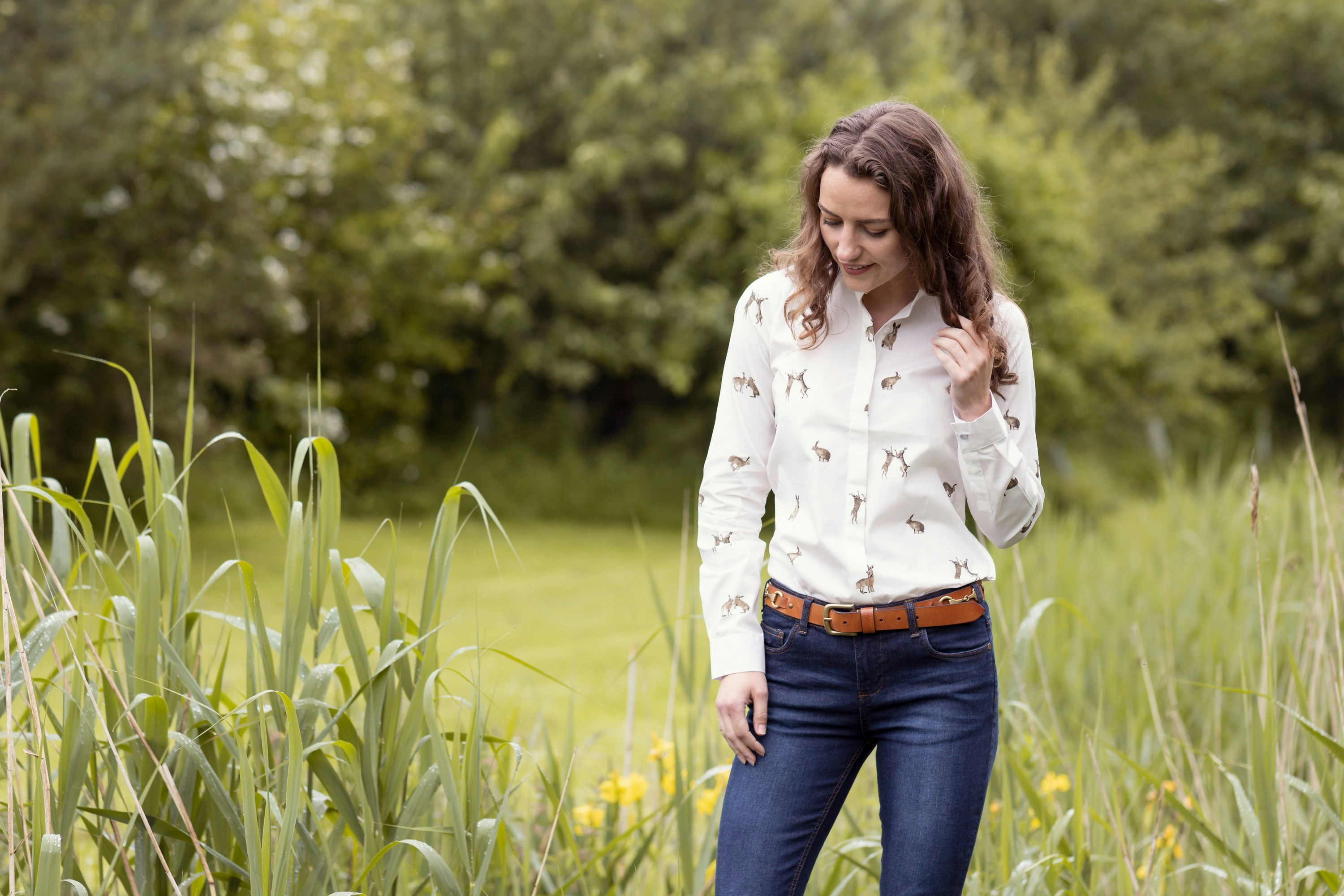 a woman standing in a field of tall grass