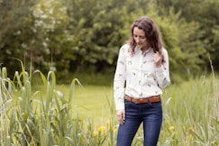 a woman standing in a field of tall grass