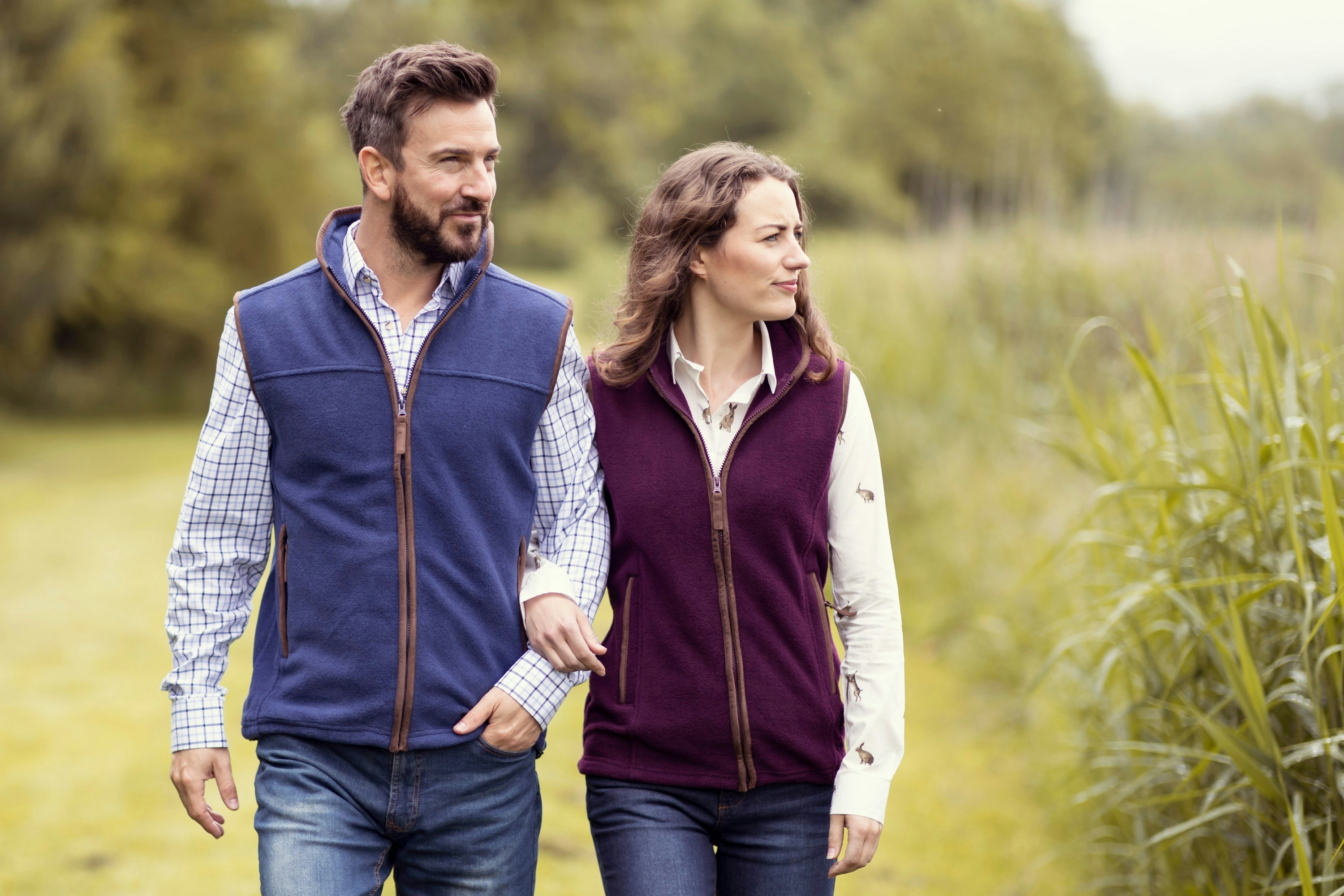 un homme et une femme marchant dans un champ