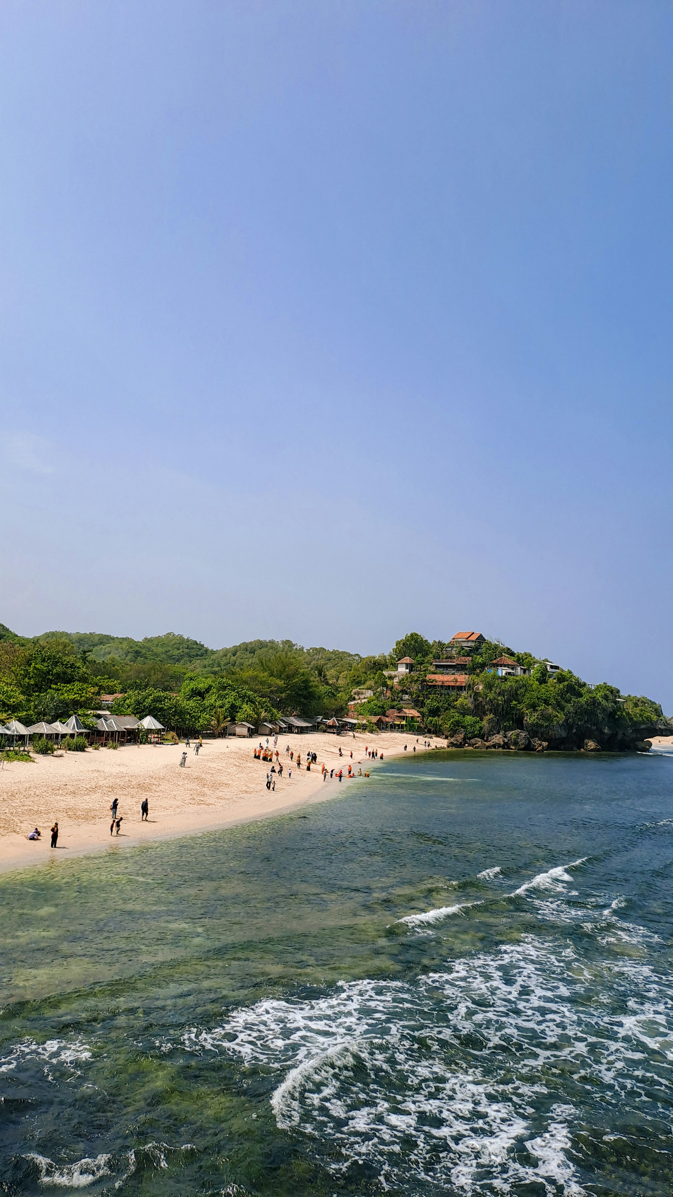 A group of people standing on top of a sandy beach photo – Free Beach ...