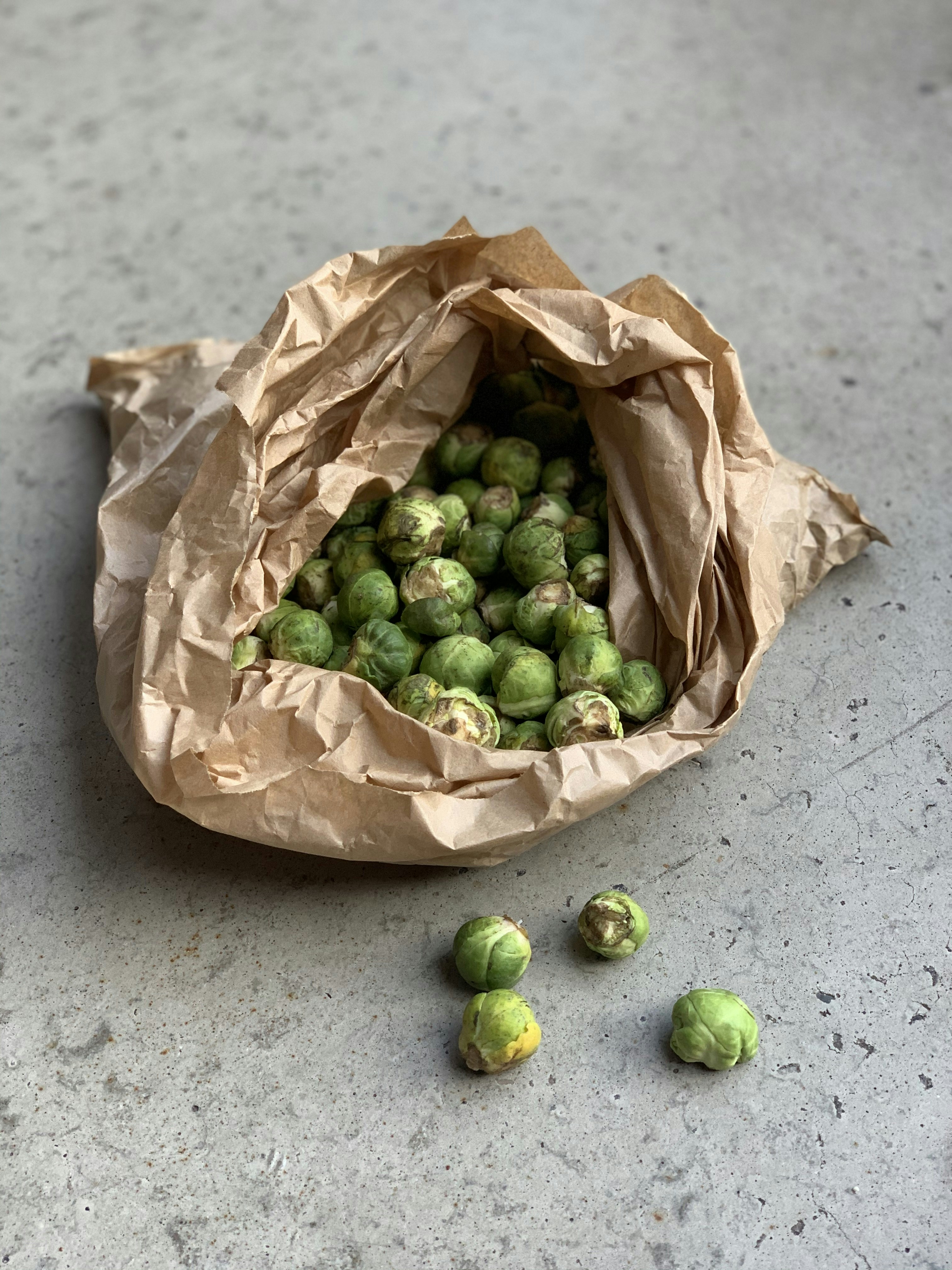 a bag full of brussel sprouts sitting on the ground