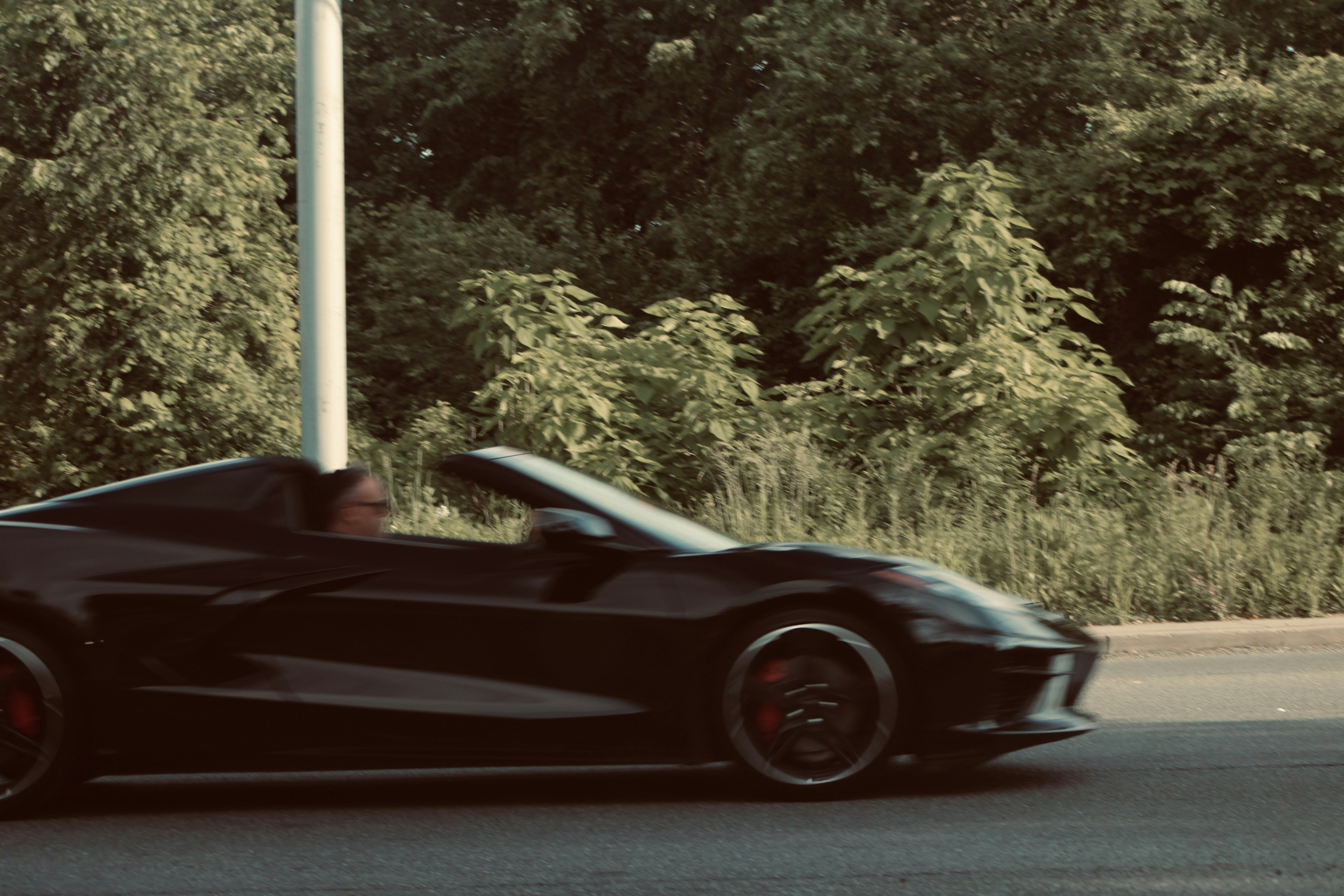 a black sports car driving down a street