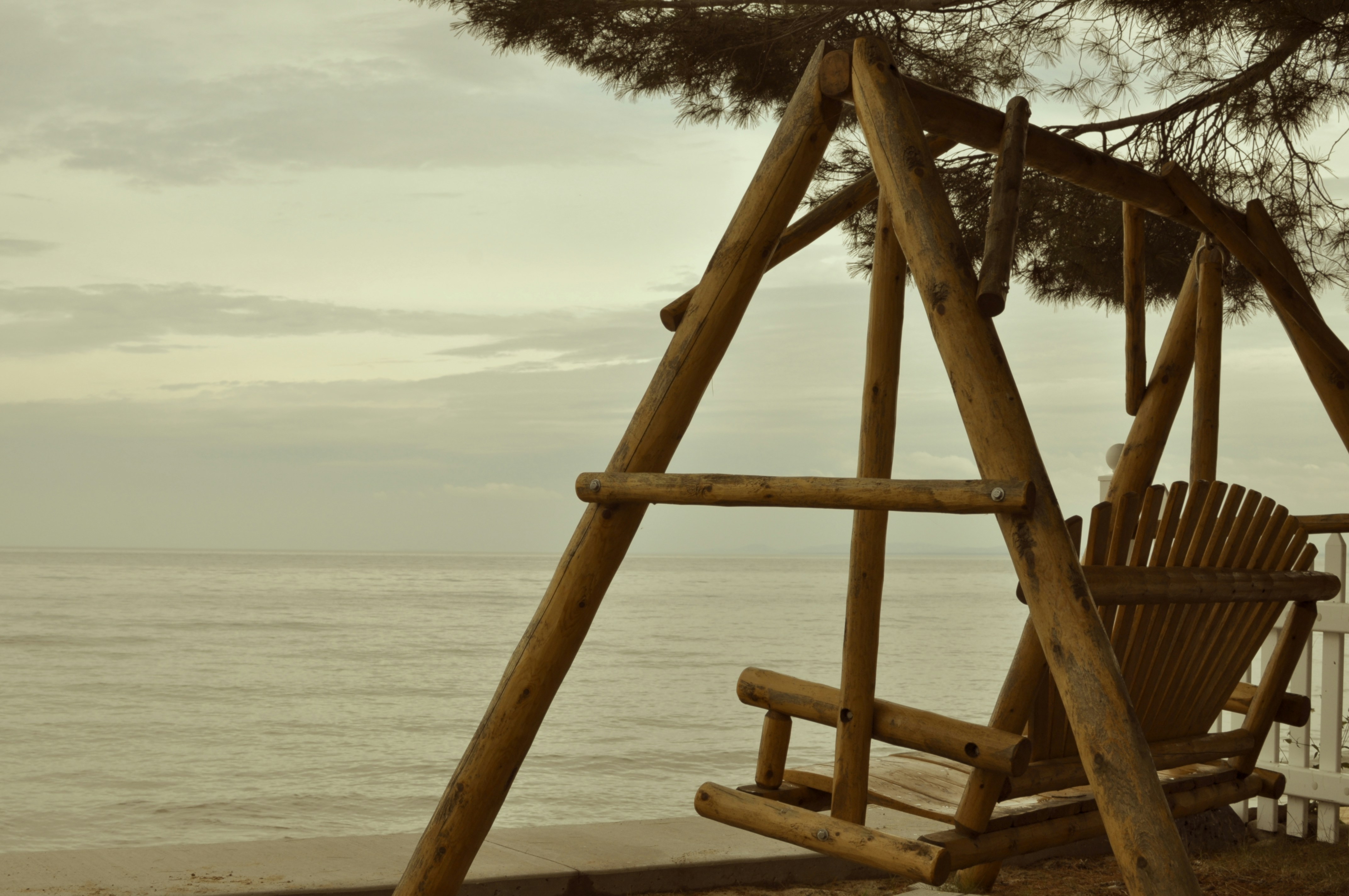 a wooden swing set sitting on top of a sandy beach