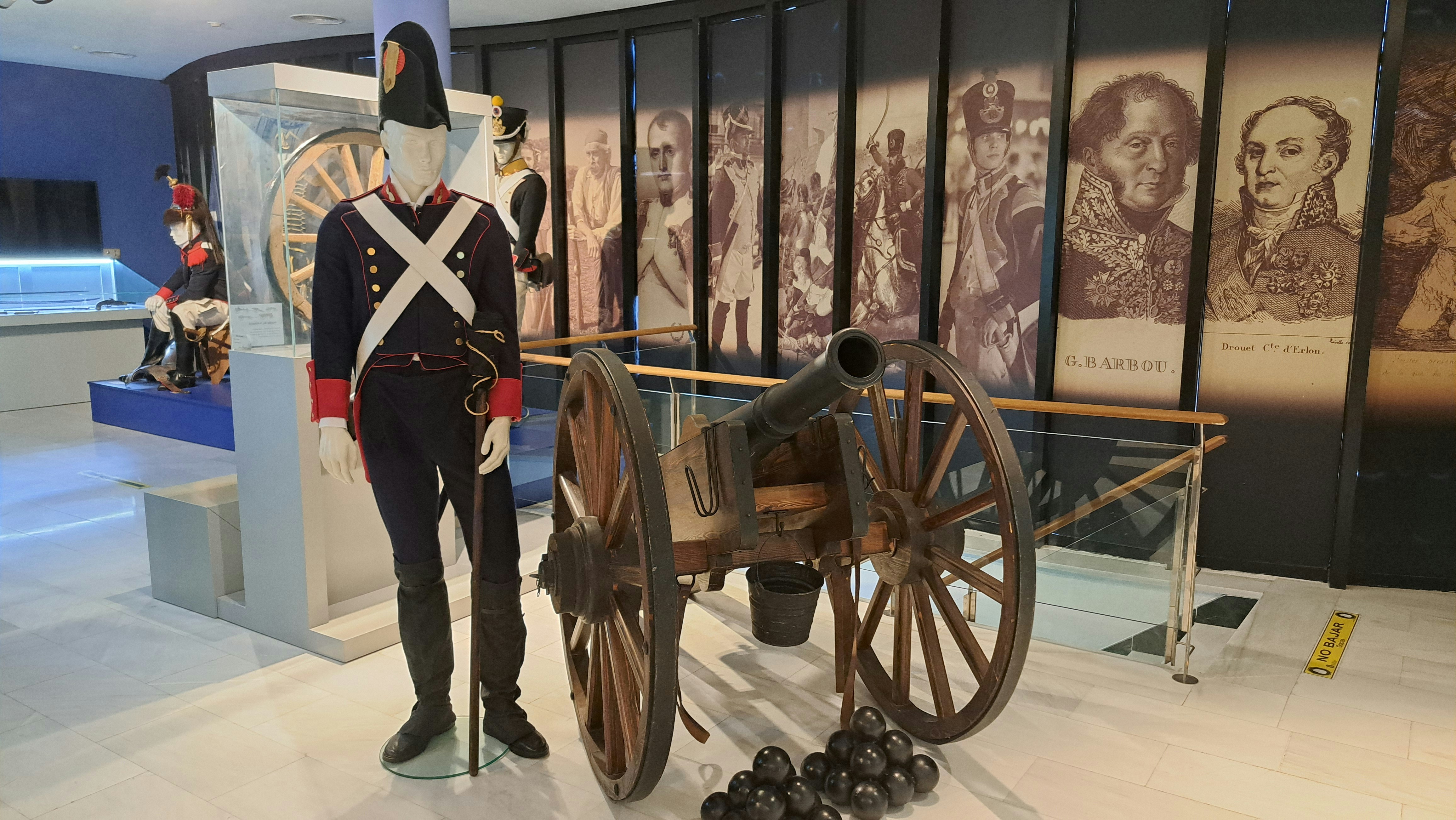 a man standing next to a cannon in a museum