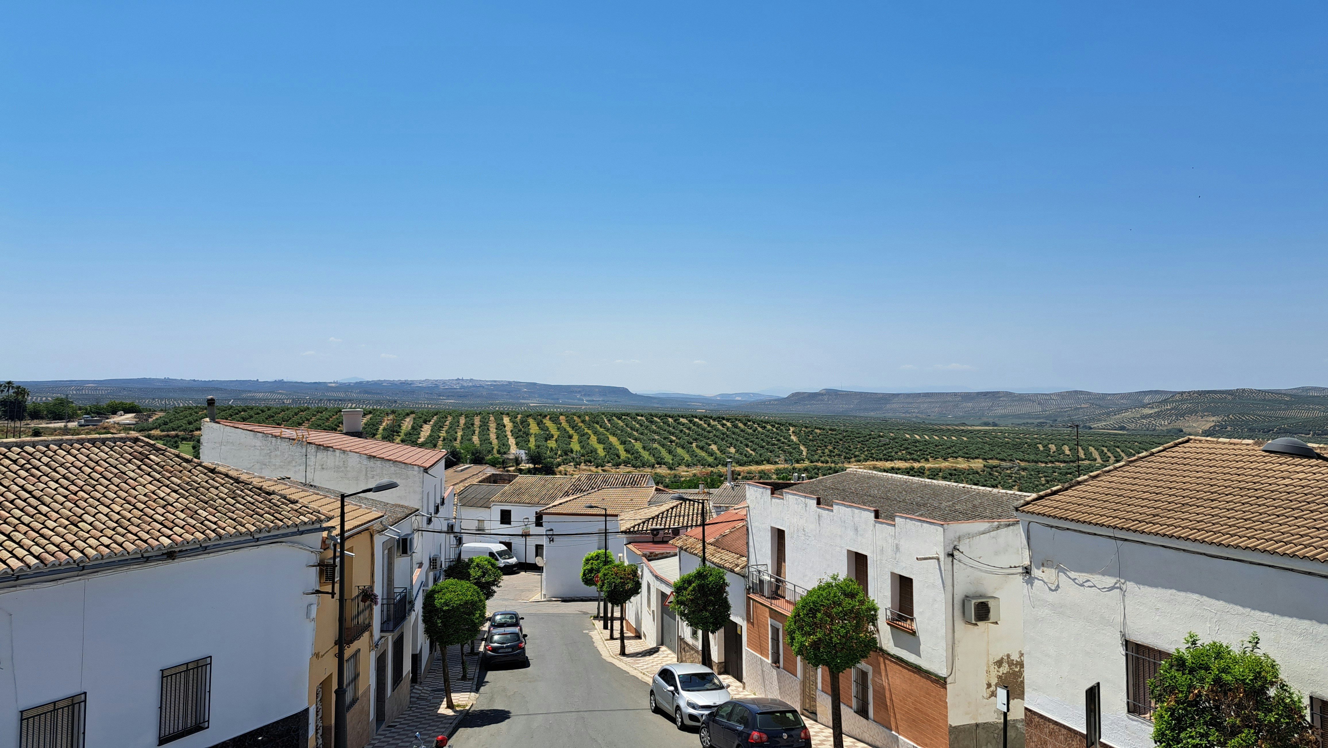 a view of a street with cars parked on the side of it