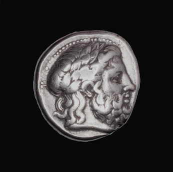 Ancient silver coin with profile of bearded man.