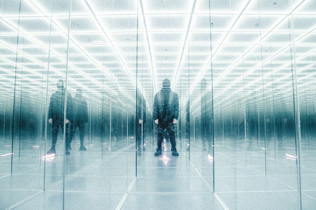 a group of people standing in a room with mirrors