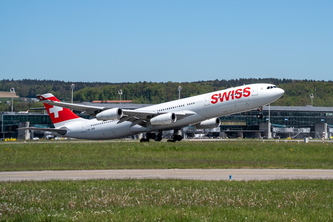 a large passenger jet sitting on top of an airport runway, A Swiss Air Airbus A343 taking off from Zurich Airport.