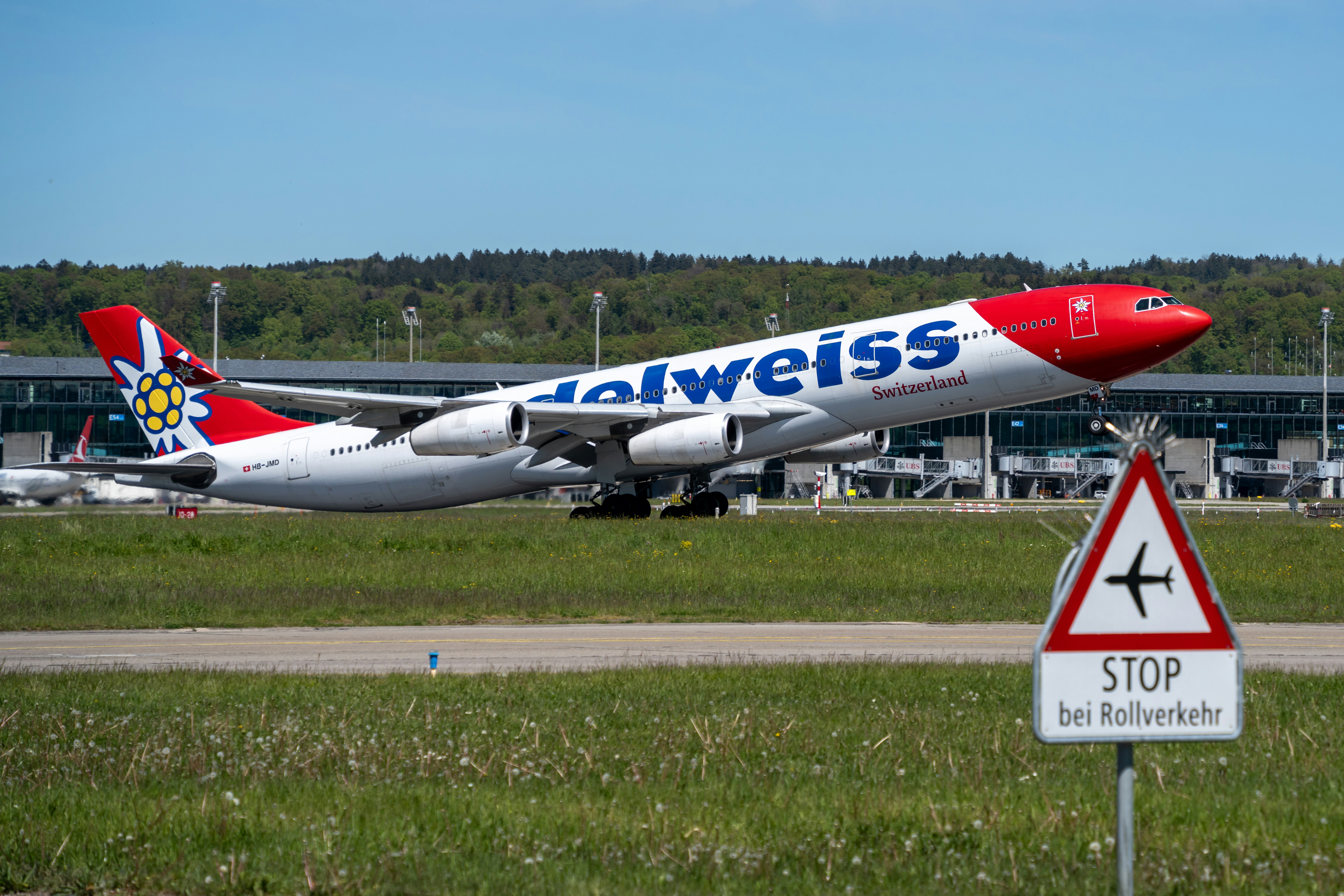 a large jetliner sitting on top of an airport runway, An Edelweiss Airbus A343 taking off from Zurich Airport.