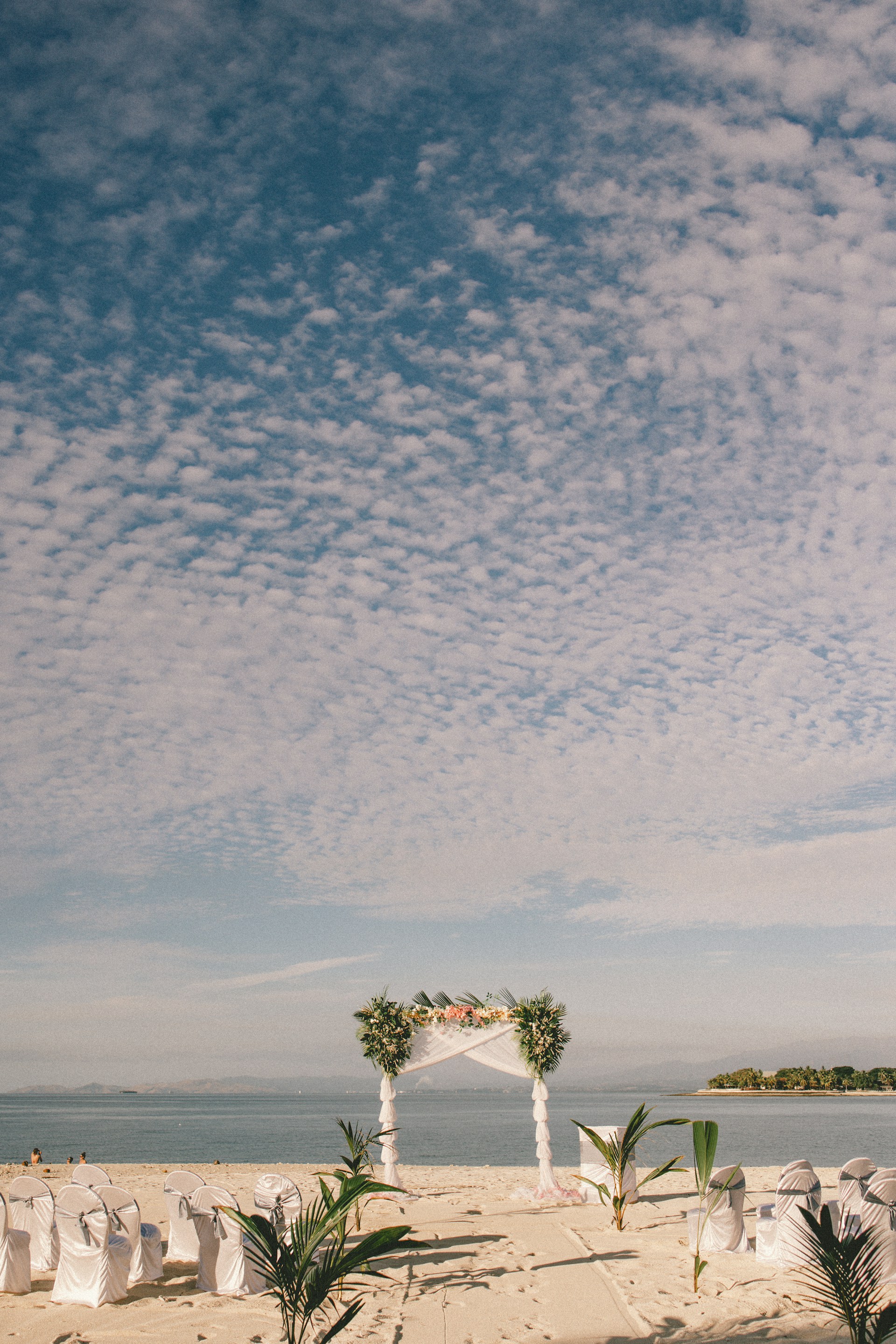 a wedding setup on the beach under a cloudy sky