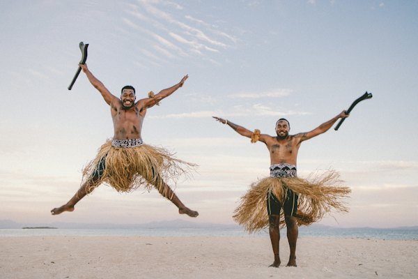 A couple of men standing on top of a sandy beach — Fiji, Fiji