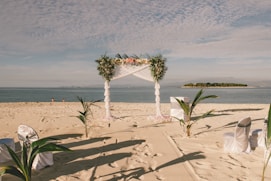 a wedding setup on the beach with a view of the ocean