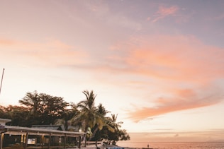a boat is parked on the beach at sunset