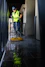 a man in a yellow vest is cleaning the floor