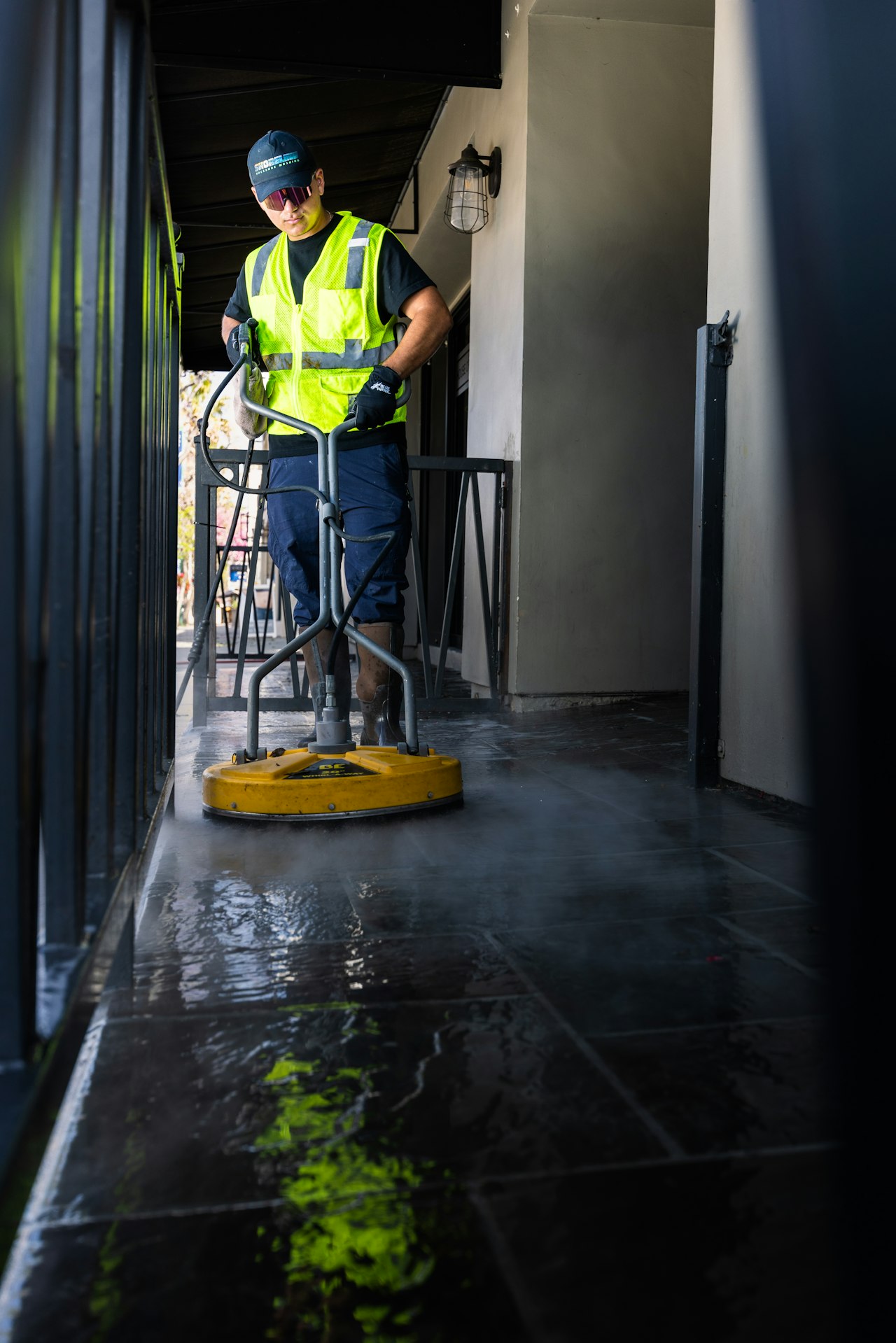 Agent de propreté en gilet jaune utilisant une monobrosse électrique pour nettoyer un sol mouillé