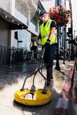 a man in a yellow vest is cleaning the street
