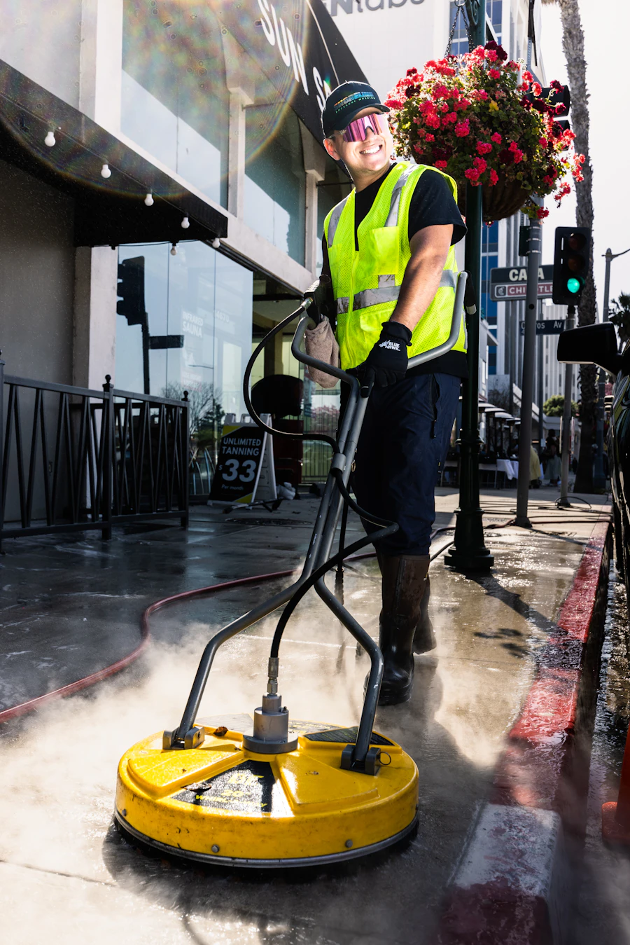 Technician pressure washing a paved surface