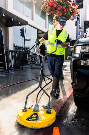 a man in a yellow vest is cleaning a street