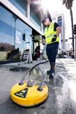 a man in a yellow vest is cleaning the street
