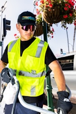 a man wearing a safety vest and holding a hose
