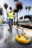 a man in a yellow vest is cleaning the street
