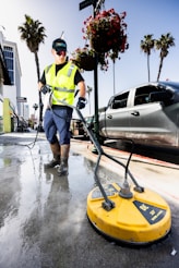 a man in a yellow vest is cleaning the street
