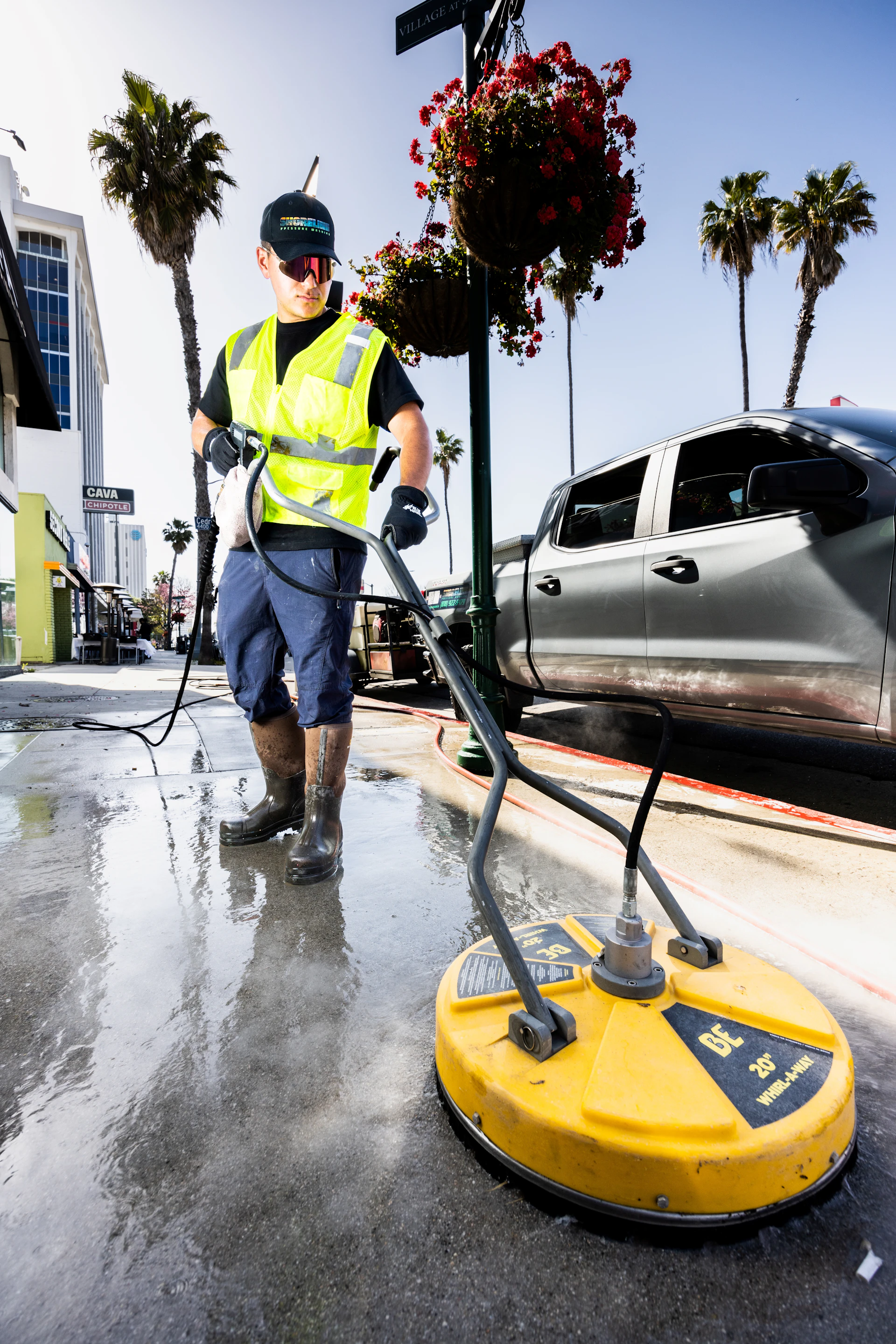 Technician pressure washing an exterior path