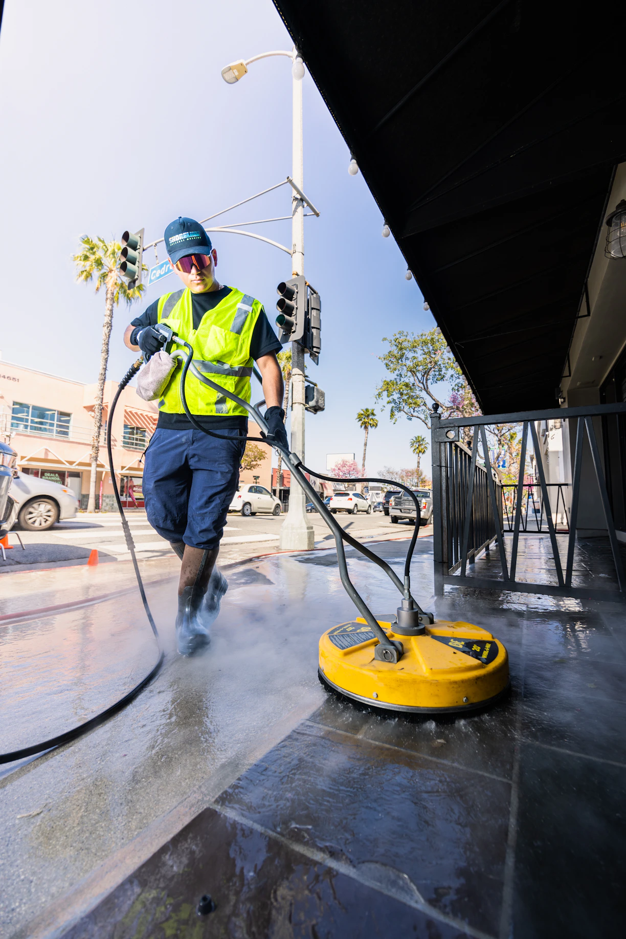 a man in a yellow vest is cleaning a street