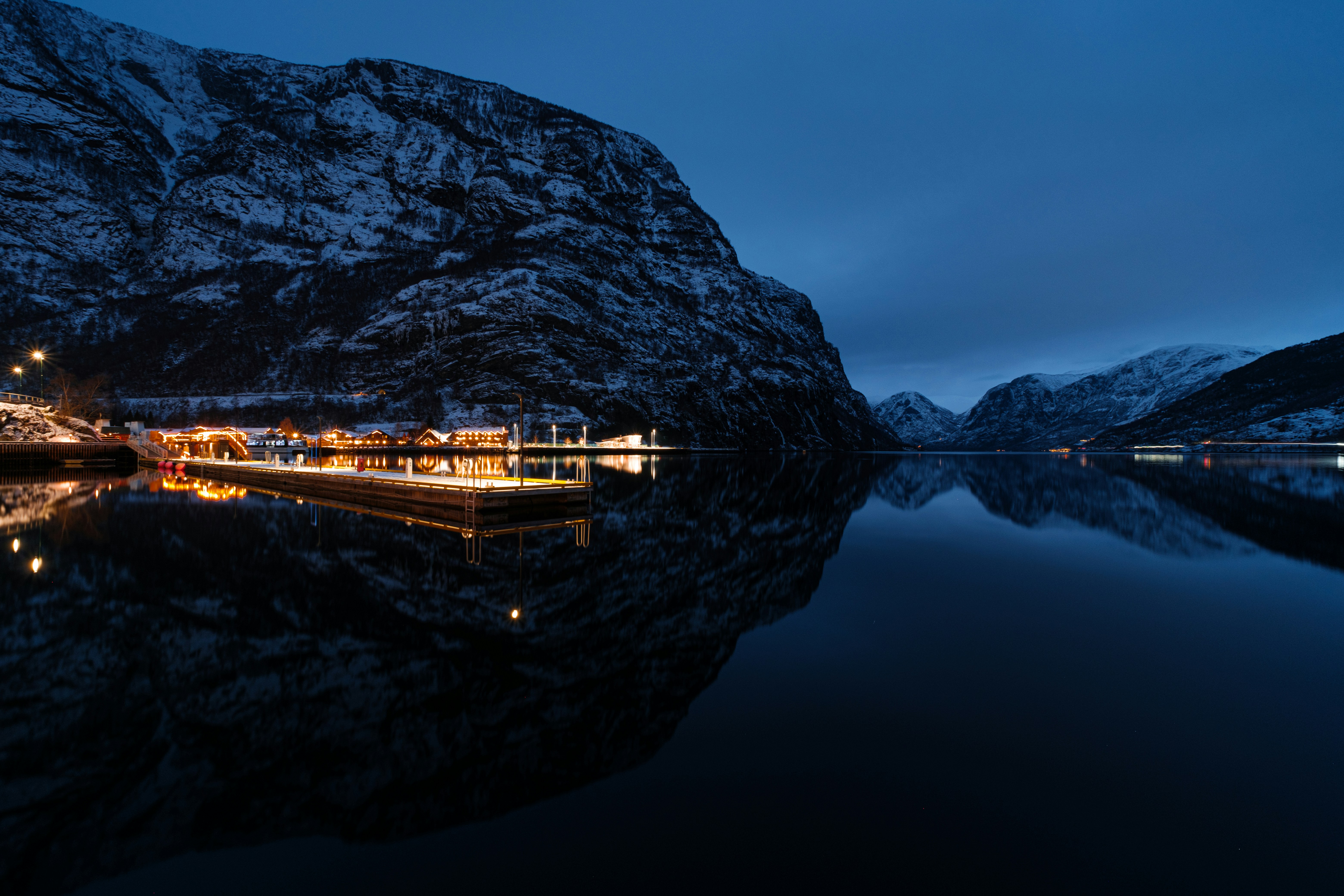 a boat in a body of water with mountains in the background, 
