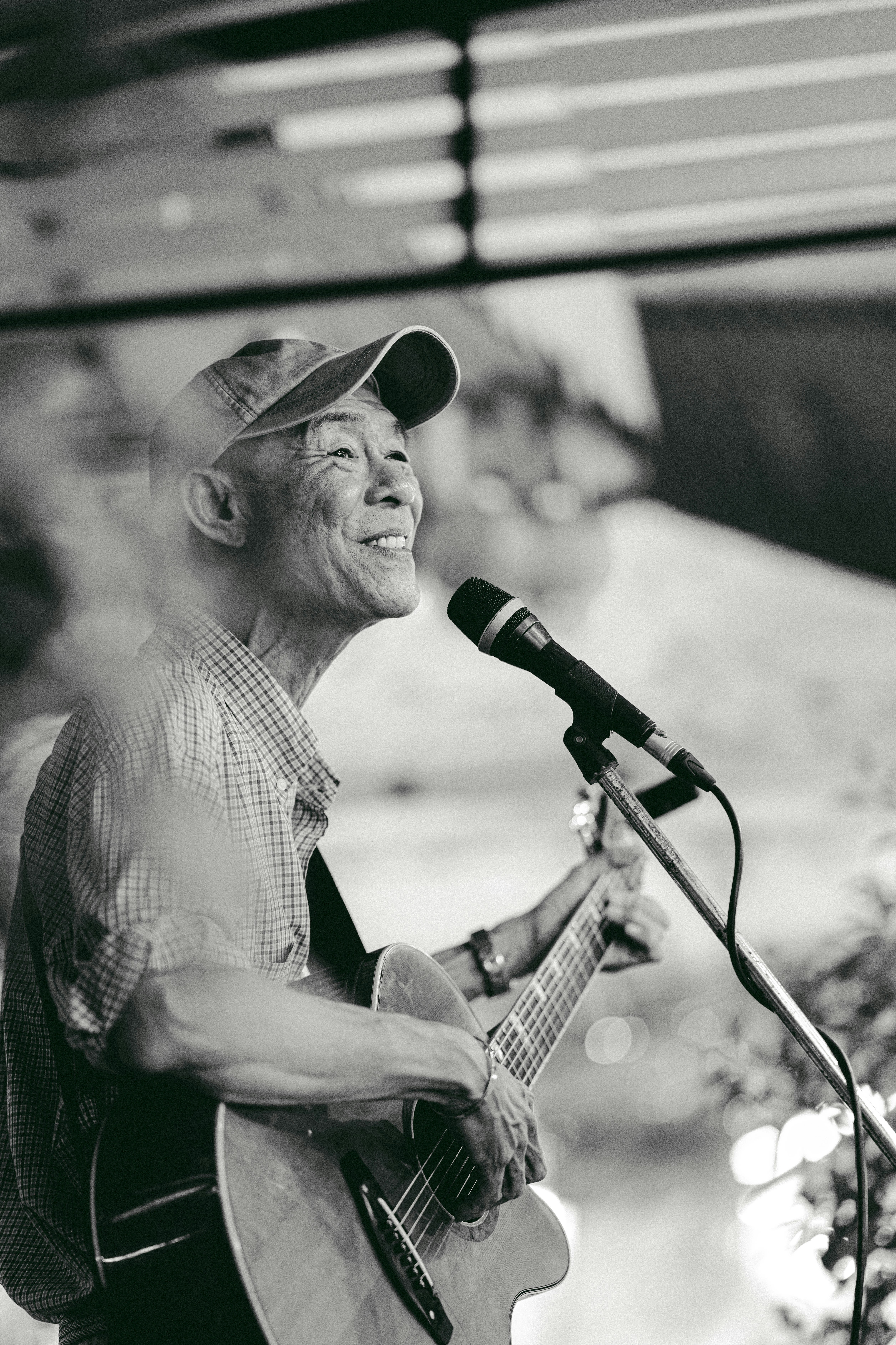 a man playing a guitar and singing into a microphone