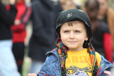 a young boy wearing a jacket and a hat