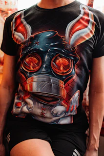a man wearing a t - shirt with a mask on it