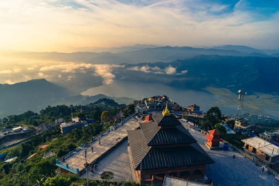 an aerial view of a building with mountains in the background