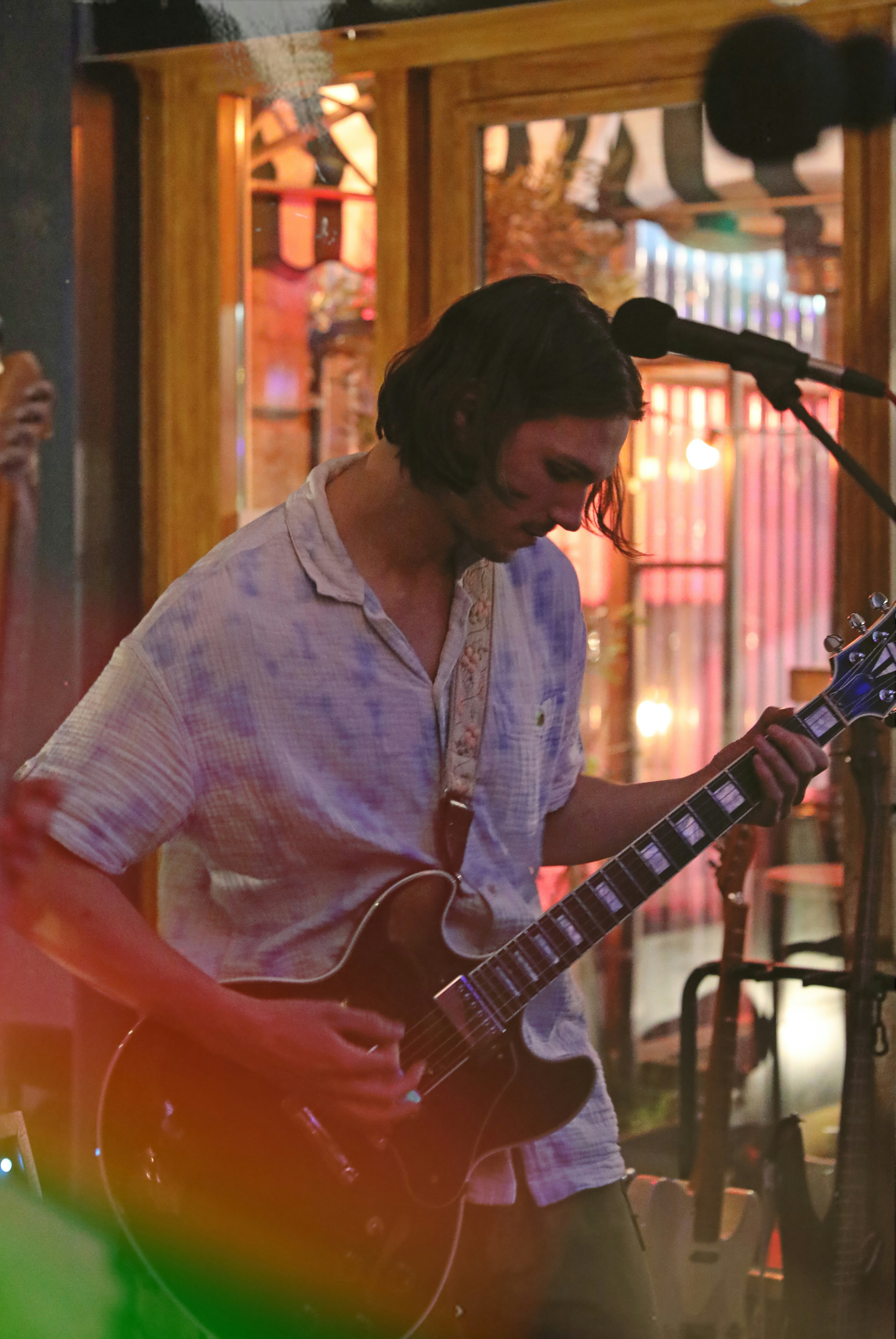 a man playing a guitar in front of a microphone