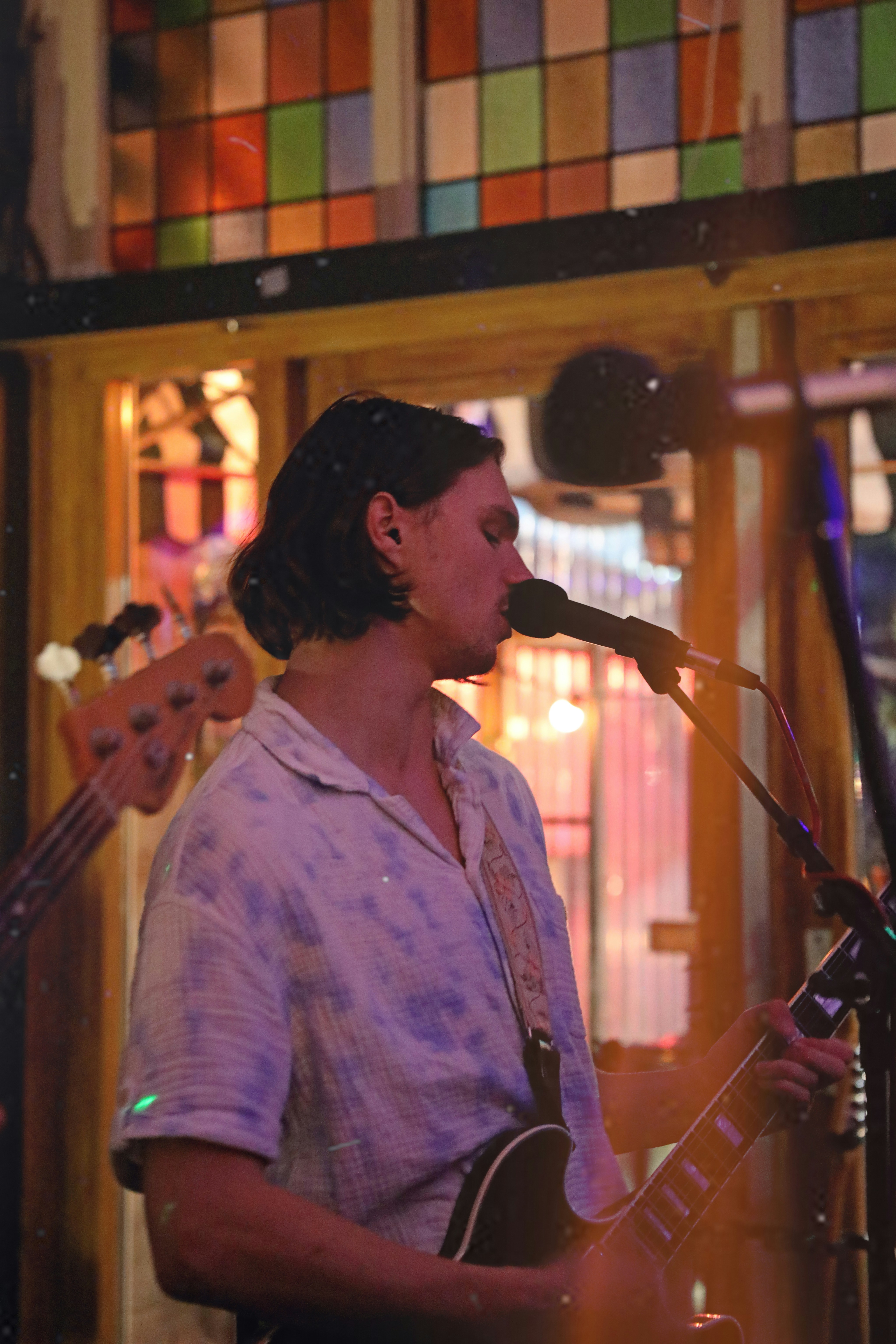 a man playing a guitar and singing into a microphone