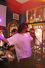 a man singing into a microphone while holding a guitar