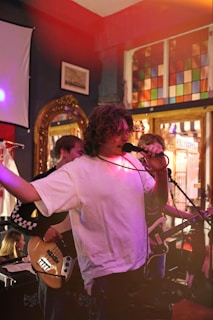 a man singing into a microphone while holding a guitar