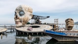 a sculpture of a human head is in the water
