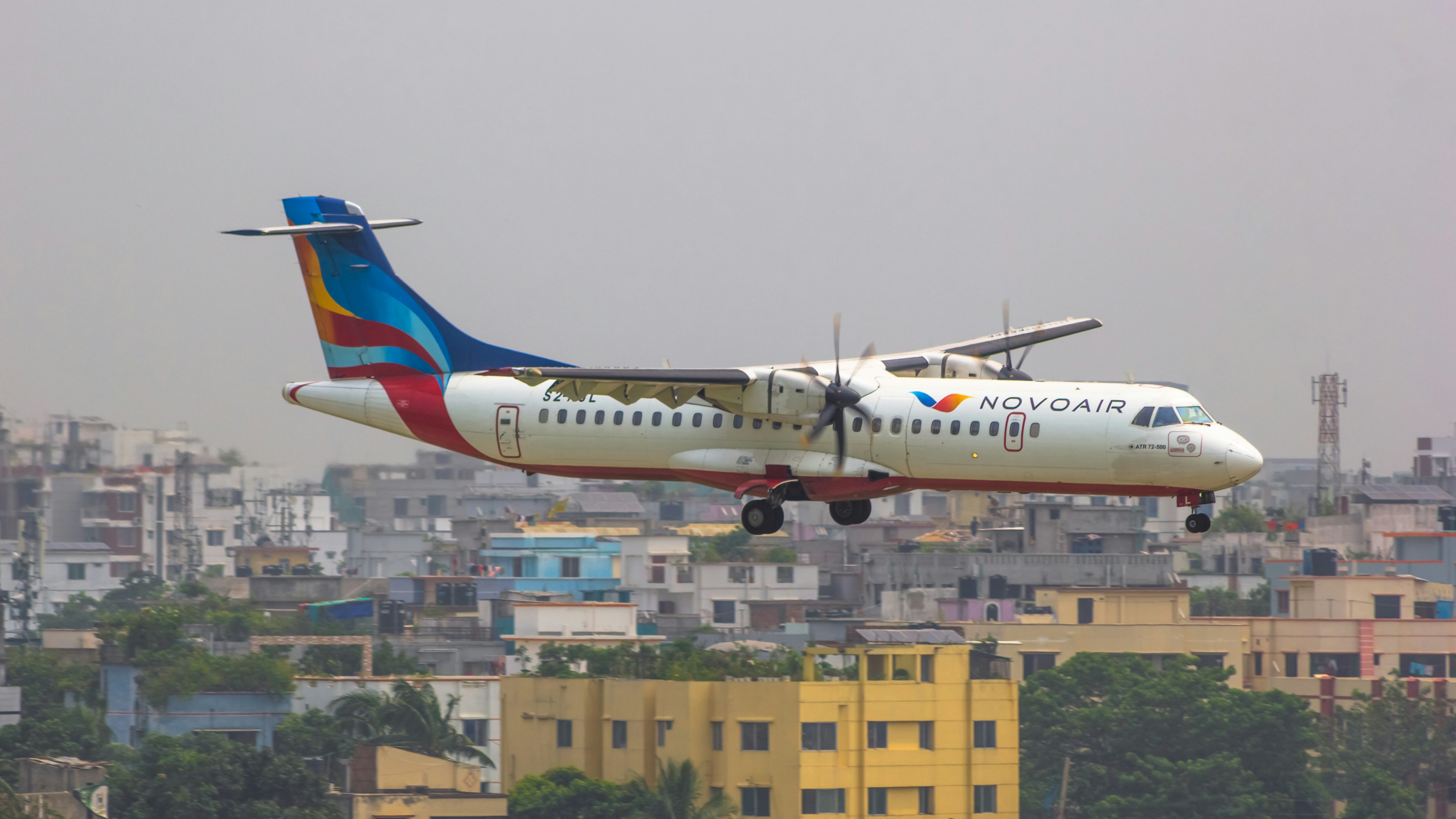 a large passenger jet flying over a city, 