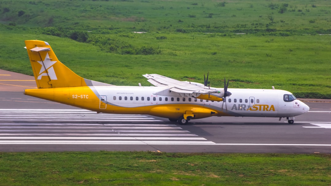 a yellow and white airplane is on the runway,