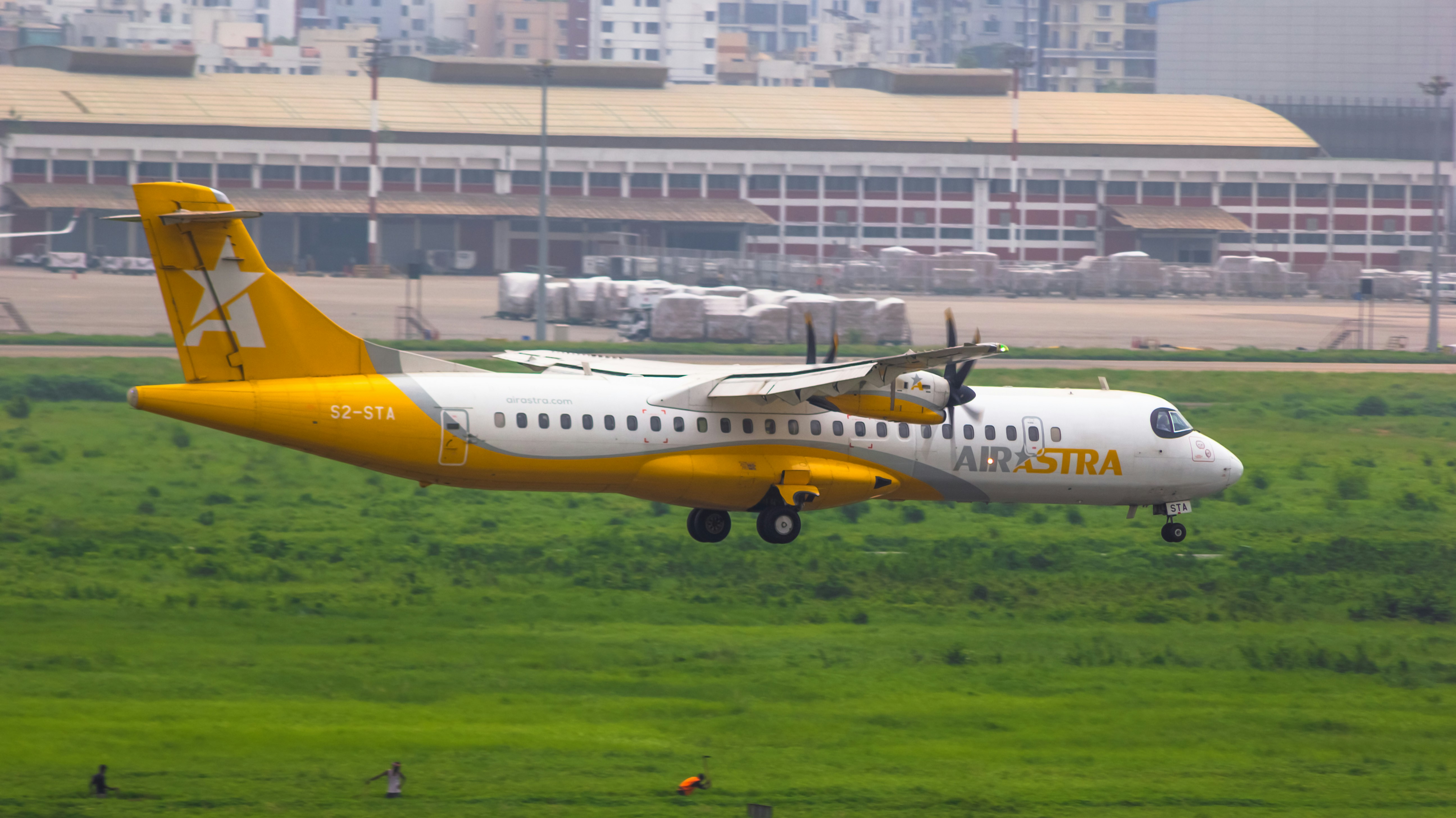 a yellow and white airplane taking off from an airport, 