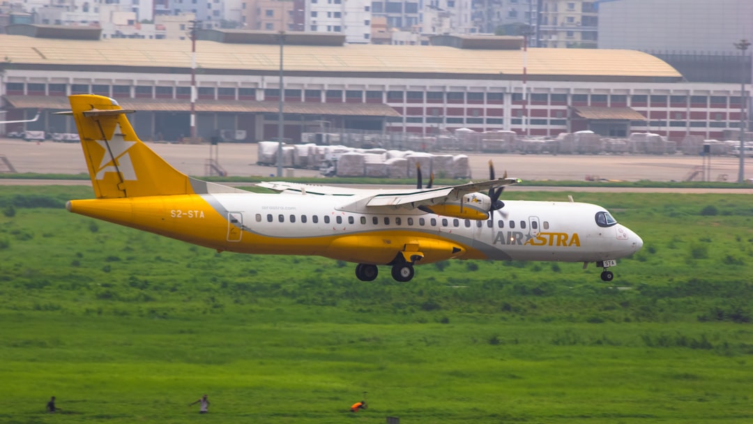a yellow and white airplane taking off from an airport,