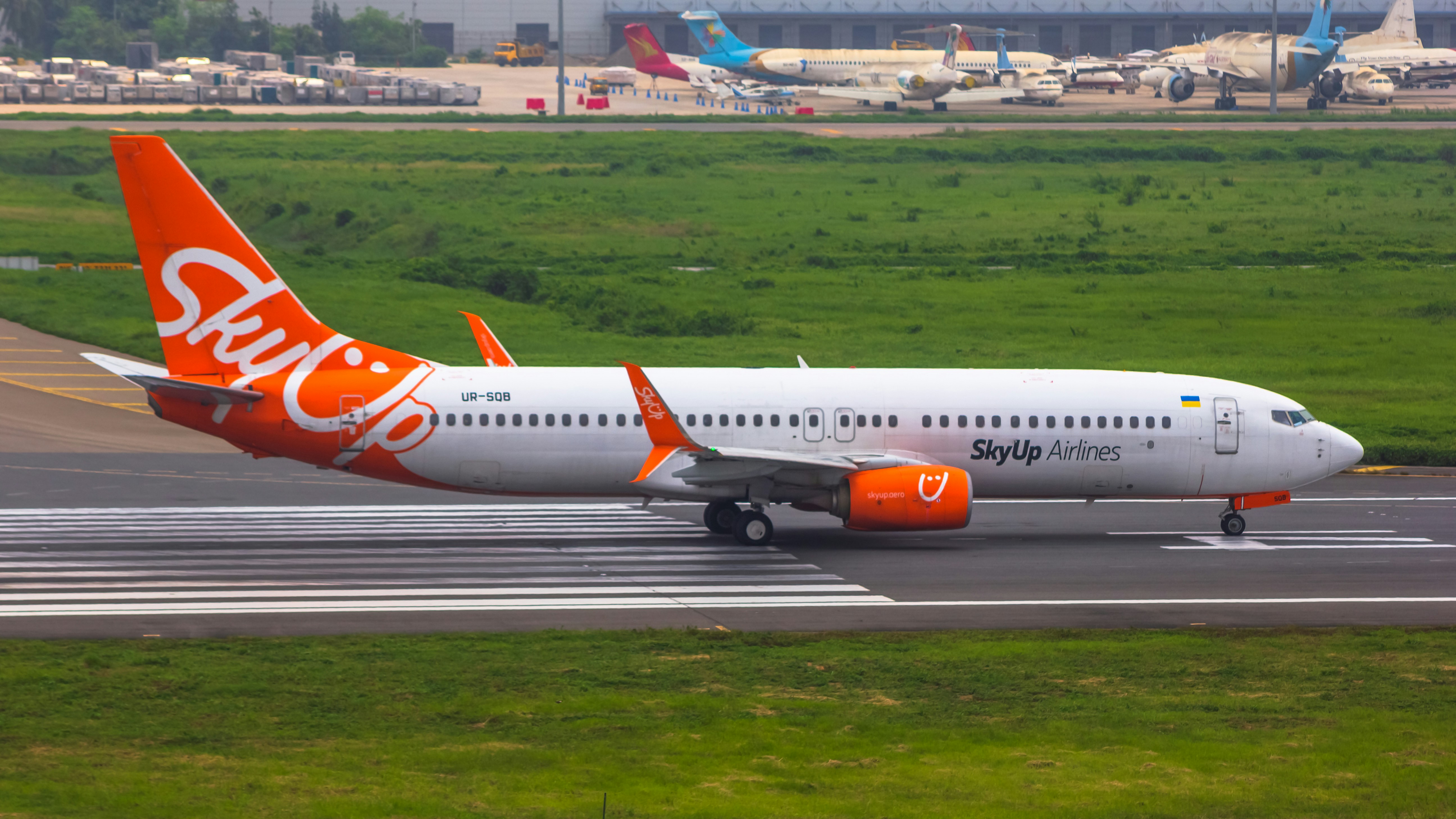 an orange and white jet airliner on a runway, 
