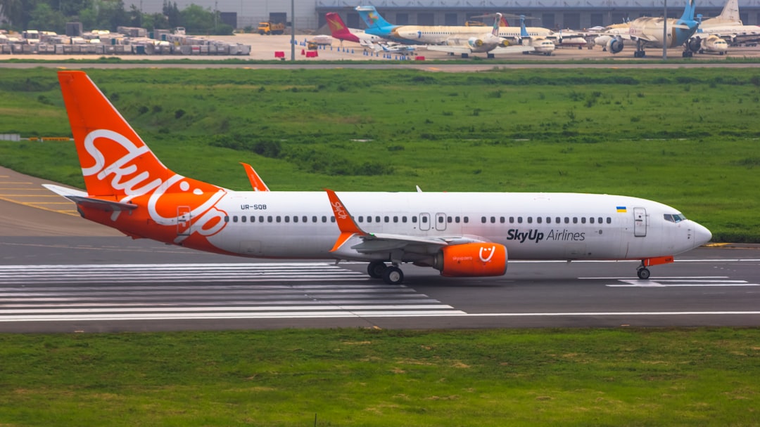 an orange and white jet airliner on a runway,