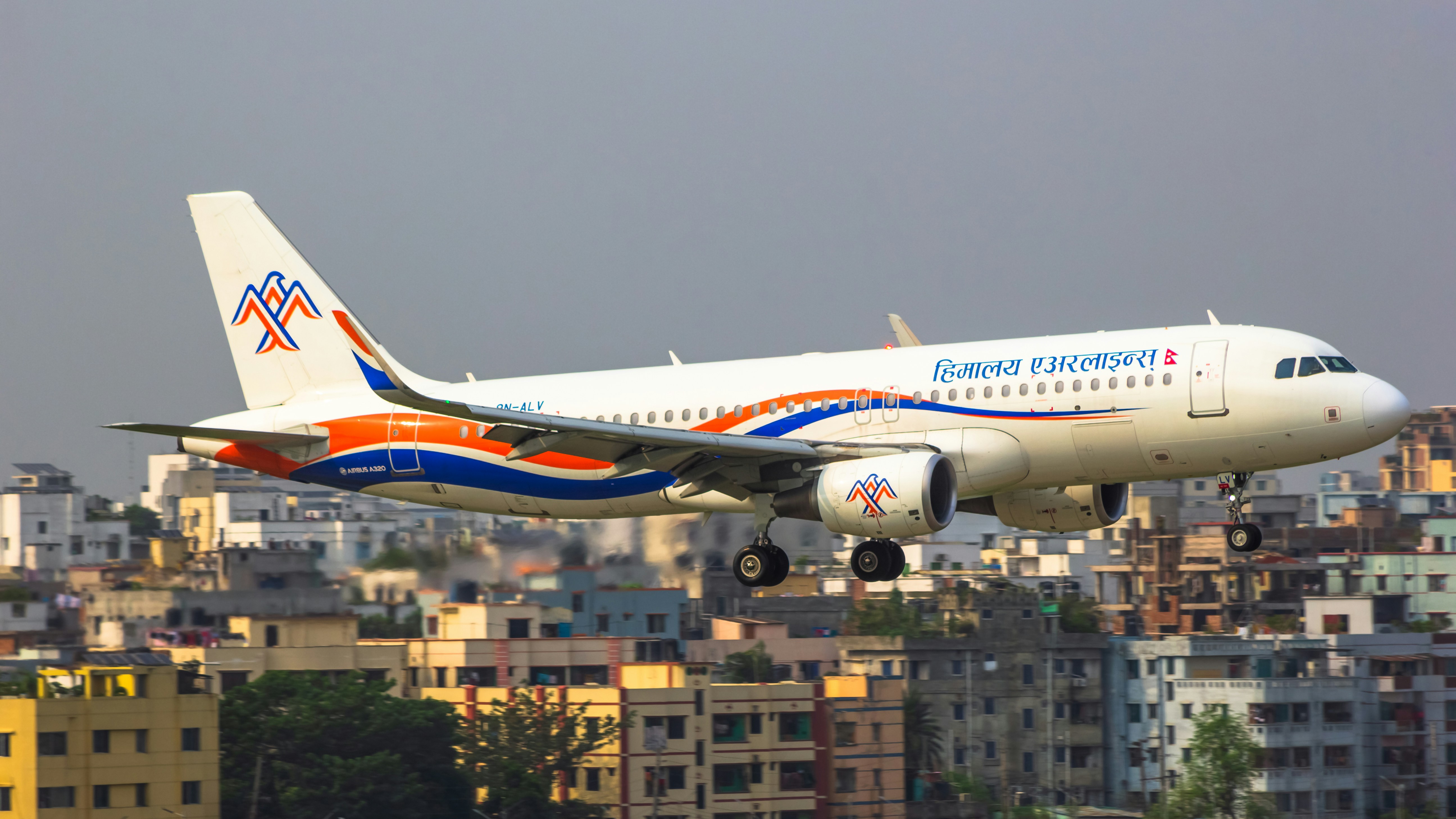a large passenger jet flying over a city, 