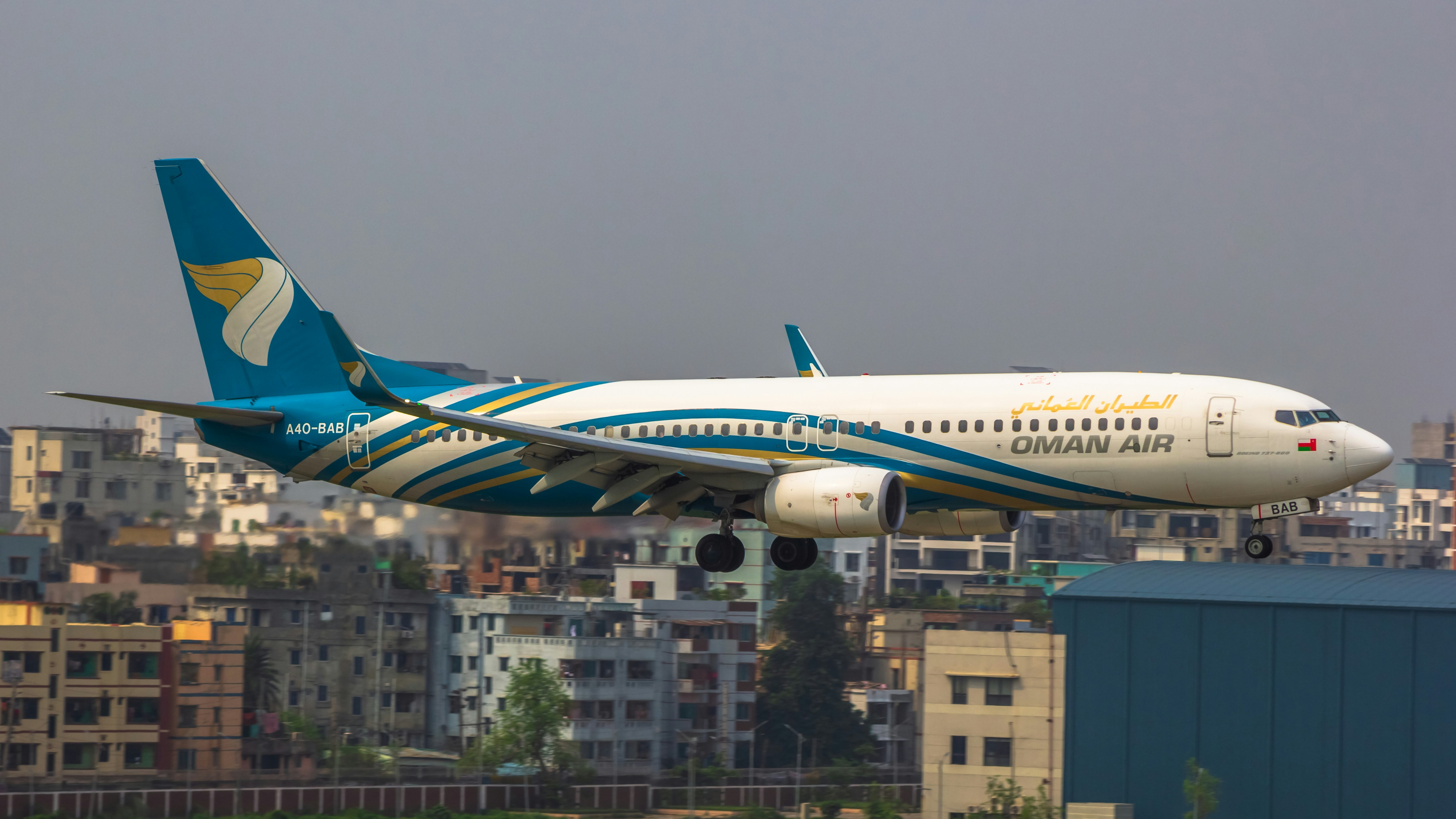 a large passenger jet flying over a city, 