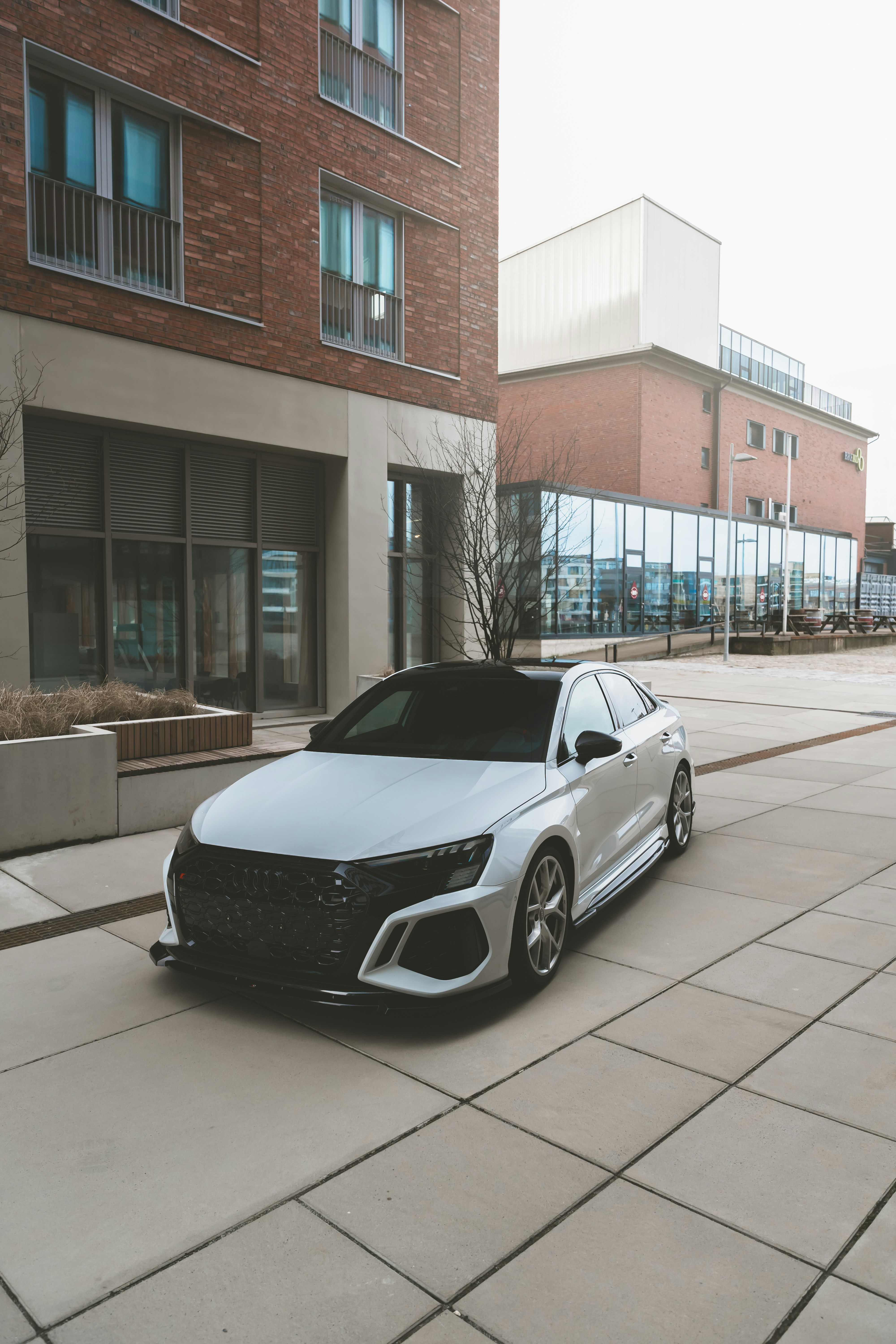 Un coche blanco aparcado frente a un edificio